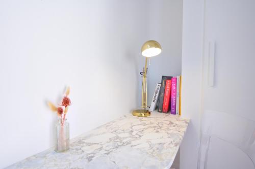 une table avec une lampe et un vase sur elle dans l'établissement Duplex standing 7min➤Fontainebleau-INSEAD⎮45min➤Paris, à Veneux-les-Sablons