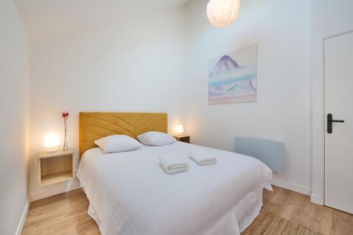 1 dormitorio con 1 cama blanca y 2 toallas en Duplex standing 7min➤Fontainebleau-INSEAD⎮45min➤Paris en Veneux-les-Sablons