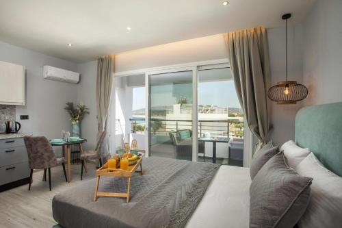 sypialnia z łóżkiem i biurkiem ze stołem w obiekcie Haraki Blue Dream Luxury Apartments w mieście Charaki