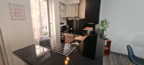 kuchnia ze szklanym stołem i blatem w obiekcie La maison de Lily au cœur de la cité Médiévale w mieście Sarlat-la-Canéda