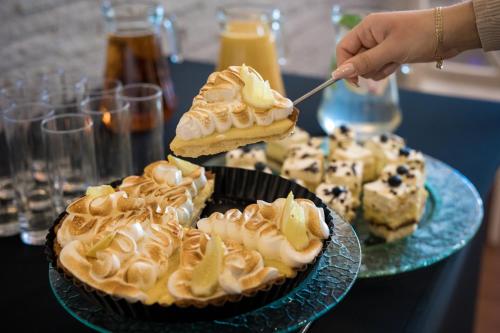 a person is reaching for a piece of pie on a table at Centrum Konferencyjno Rekreacyjne Molo in Smardzewice