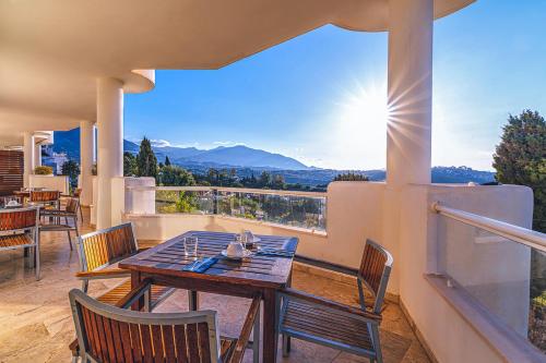 ミハスにあるAparthotel Cordial Mijas Golfの景色を望むバルコニー(テーブル、椅子付)