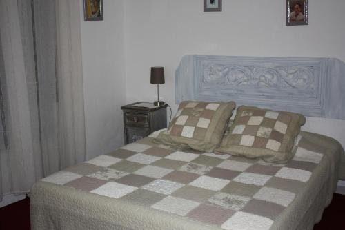 um quarto com uma cama com um cobertor e almofadas xadrez em RESIDENCE LE 360 em La Ciotat