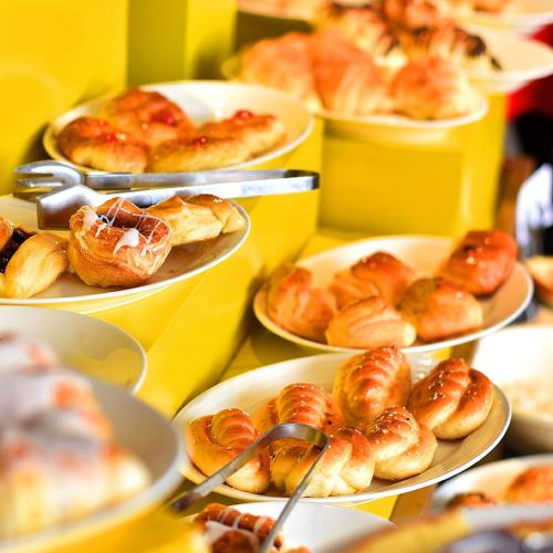 a bunch of different types of pastries on plates on a table at Indigo Heights Hotel & Suites in Lahore