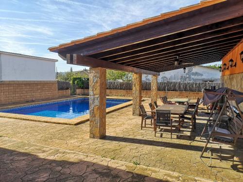 a patio with a table and chairs next to a pool at Casa Martina in Cardedeu