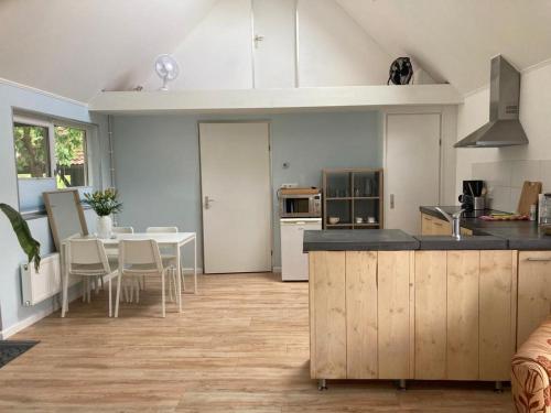 a kitchen with a counter and a table with chairs at The Bee - Trekkershuts & Apartment in Opperdoes