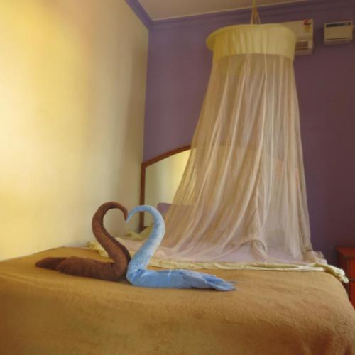 a bed with two swans made to look like hearts at Thilak Home Stay in Hampi