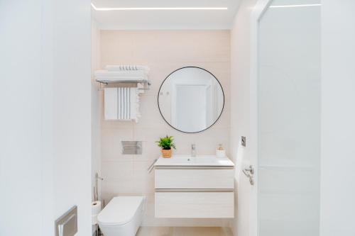 a white bathroom with a sink and a mirror at Mara Marina Suites 4 in Playa Blanca