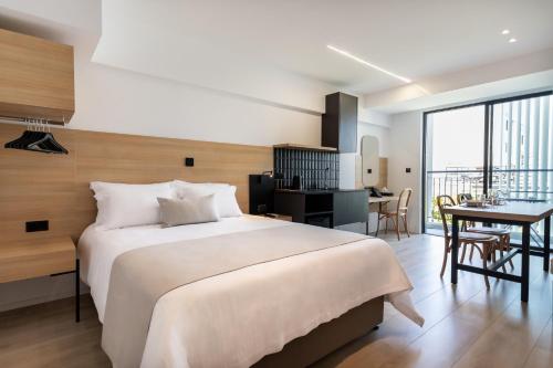 a bedroom with a large white bed and a desk at Alinea Urban Saripolou Square in Limassol