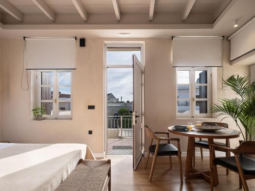a bedroom with a bed and a table and chairs at Lithinon Luxury Suites Old Town Chania free on-site Parking in Chania