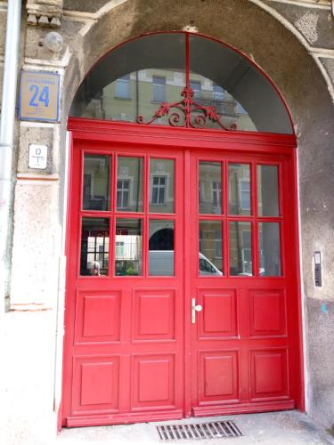 una puerta roja en un edificio con un arco en Tulip Jagiellonska - poddasze bez windy, en Szczecin