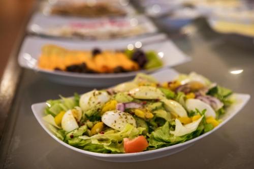 a salad in a white bowl on a table at Centrum Konferencyjno Rekreacyjne Molo in Smardzewice