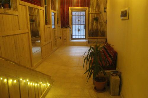 a hallway with a door and a plant and lights at 7 Caves Hotel in Al Jāyah