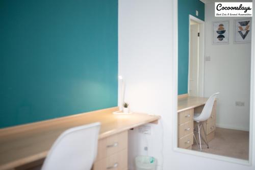 a room with a desk with two chairs and a mirror at Cocooonstays Short Lets & Serviced Accommodation Hayes in Hayes
