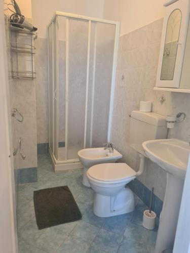 een badkamer met een toilet, een wastafel en een douche bij La Casa di Aldo al Mare in Ospedaletti