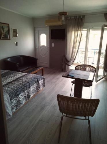 a bedroom with a bed and two chairs and a table at Minimal & cozy studio ΜΕ ΔΩΡΕΑΝ ΧΩΡΟ ΣΤΑΘΜΕΥΣΗΣ in Kavala
