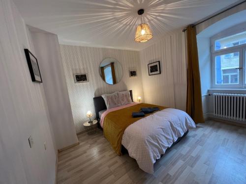 a bedroom with a bed and a large window at Ca s'est passé à la Cour-Aux-Moines in Porrentruy