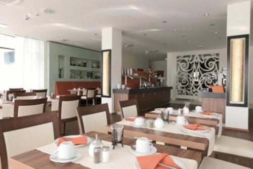 uma sala de jantar com mesas e cadeiras num restaurante em Qualitel Hilpoltstein em Hilpoltstein