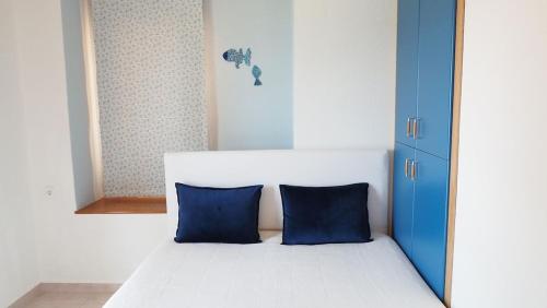 1 dormitorio con 1 cama con 2 almohadas azules en Yades elegant villa 2 minutes away from the beach en Kallithea Halkidikis