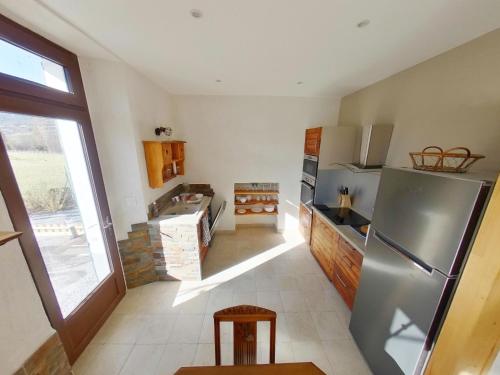 une cuisine avec un réfrigérateur en acier inoxydable dans l'établissement Appartement entier T4 à Jausiers, à Jausiers