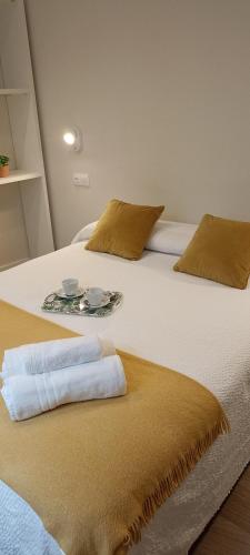 a large white bed with two towels on it at La Rua 25 in Castro-Urdiales
