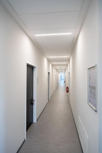 an empty corridor of an office building with white walls and a long hallway at Sportcampus Saar in Saarbrücken