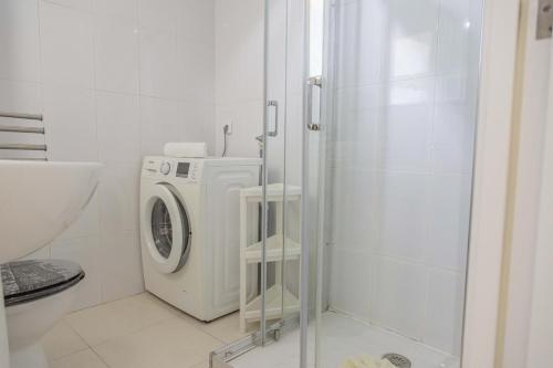 a bathroom with a washing machine and a shower at Apartamento Xara in Alcudia