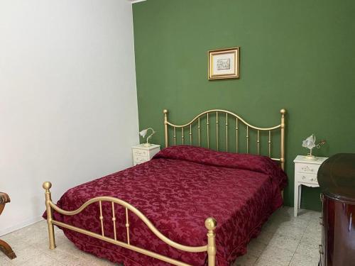 a bedroom with a bed with a red bedspread at Casa Eoliana in Taormina