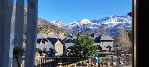 a view from a window of a village with snow covered mountains at Los Altos de Escarrilla - tucasaenlospirineos in Escarrilla