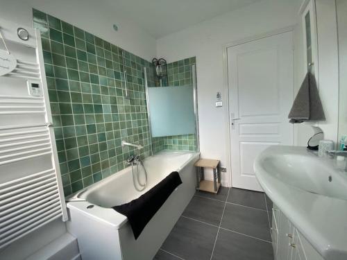 une salle de bain avec une baignoire et un lavabo et une baignoire dans l'établissement Du gite dans les Toiles, à Wimereux