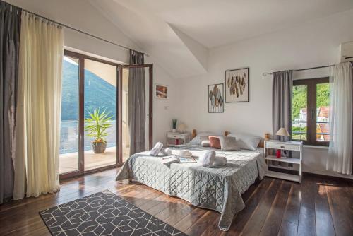 a bedroom with a bed and a large window at Apartments MaXhit in Tivat