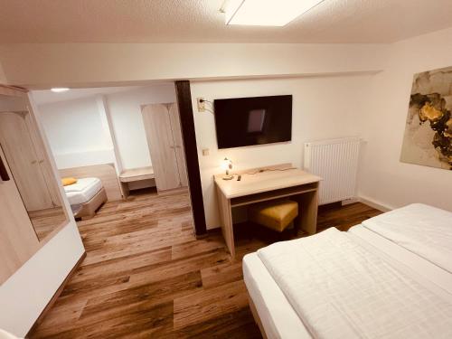 a room with a desk and a bed and a television at Villa Antonia in Bautzen