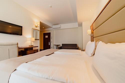a hotel room with a large bed and a desk at Radsor Hotel in Râşnov