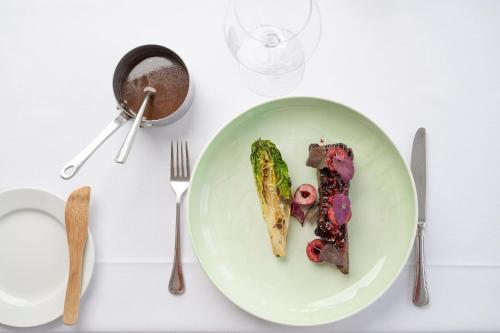 a white table with a plate of food on it at Stammershalle Badehotel in Bådsted