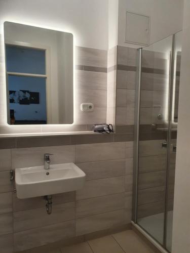 een badkamer met een wastafel en een spiegel bij Pension zum Lichtenberger in Berlijn