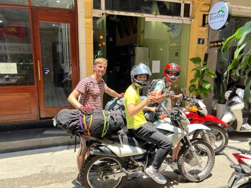 een groep van drie personen die op een motor rijden bij Hanoi EcoStay 2 hostel in Hanoi