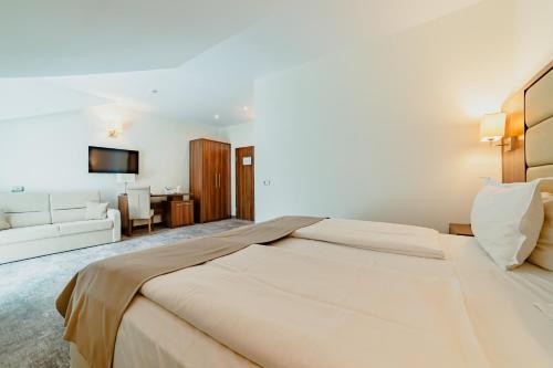 a bedroom with a large bed and a living room at Radsor Hotel in Râşnov