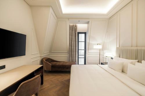 a hotel room with a bed and a flat screen tv at Mansard Riyadh, a Radisson Collection Hotel in Riyadh