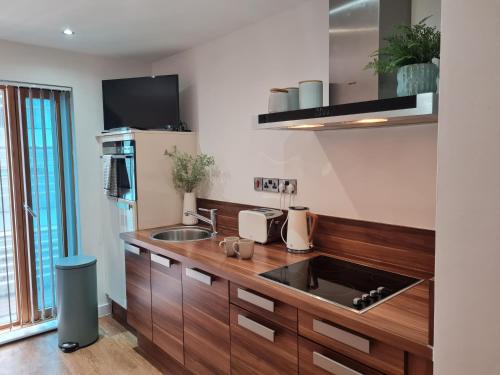 a kitchen with a wooden counter top with a sink at Sheffield City Centre Studio in Sheffield