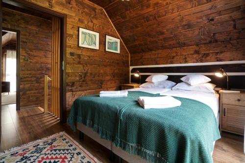 a bedroom with a bed in a wooden room at Novosiele Residence - nad górską rzeką - Leśne Spa sauna jacuzzi - Bieszczady in Bystre