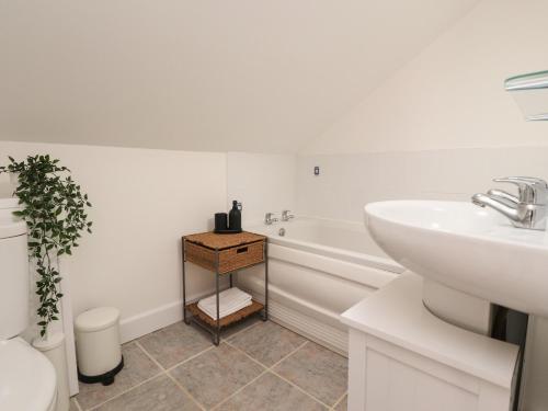 a bathroom with a sink and a toilet and a tub at Swallows Barn at Yew Tree Farm in Preston