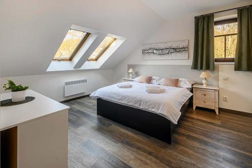 a bedroom with a king sized bed and two windows at Chalupa Křenov 62 in Bernartice