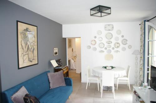 un salon avec un canapé bleu et une table dans l'établissement Petit Rêve, à LʼIsle-sur-la-Sorgue