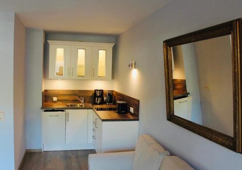 een keuken met een spiegel, een wastafel en een aanrecht bij The Lodge Braunlage in Braunlage