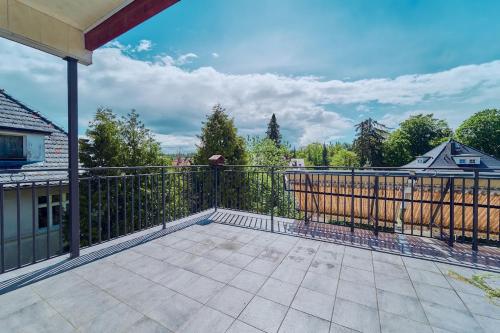 a large balcony with a fence and a patio at Marel-Apartments U SOWY- Park- Polanica Zdrój in Polanica-Zdrój