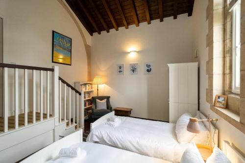 a bedroom with two beds and a chair at The Tower in Thorpeness