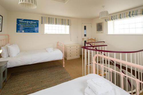 a small room with two beds and a staircase at The Tower in Thorpeness