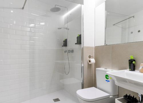 uma casa de banho com um chuveiro, um WC e um lavatório. em limehome Madrid Calle Ave María - Digital Access em Madri