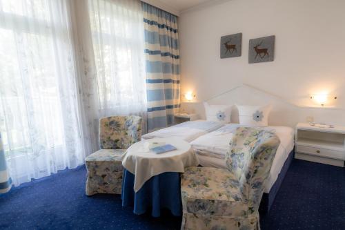 a hotel room with a bed and two chairs at Hotel Garni Hubertus-Nostalgie & Charme in Fulpmes