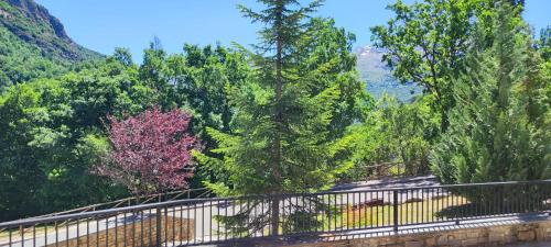 a bridge with trees and mountains in the background at Los Altos de Escarrilla - tucasaenlospirineos in Escarrilla